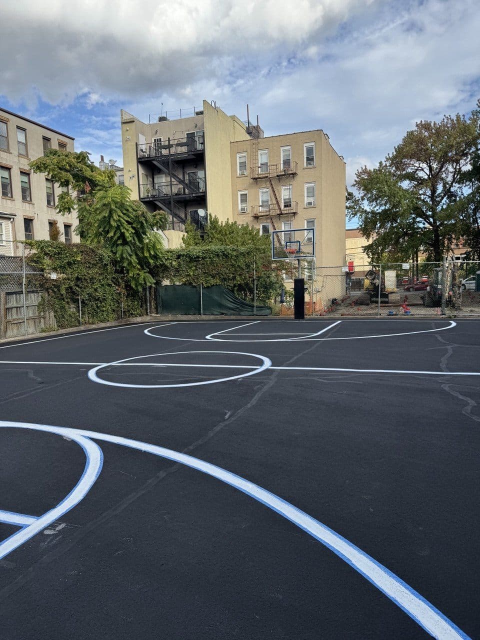 New regulation basketball lines being laid on freshly surfaced court in Hoboken, NJ