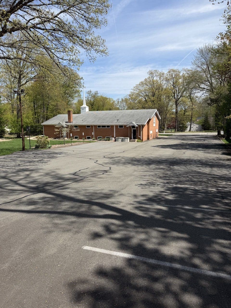 Faded, cracked commercial parking lot before sealcoating in River Vale, NJ