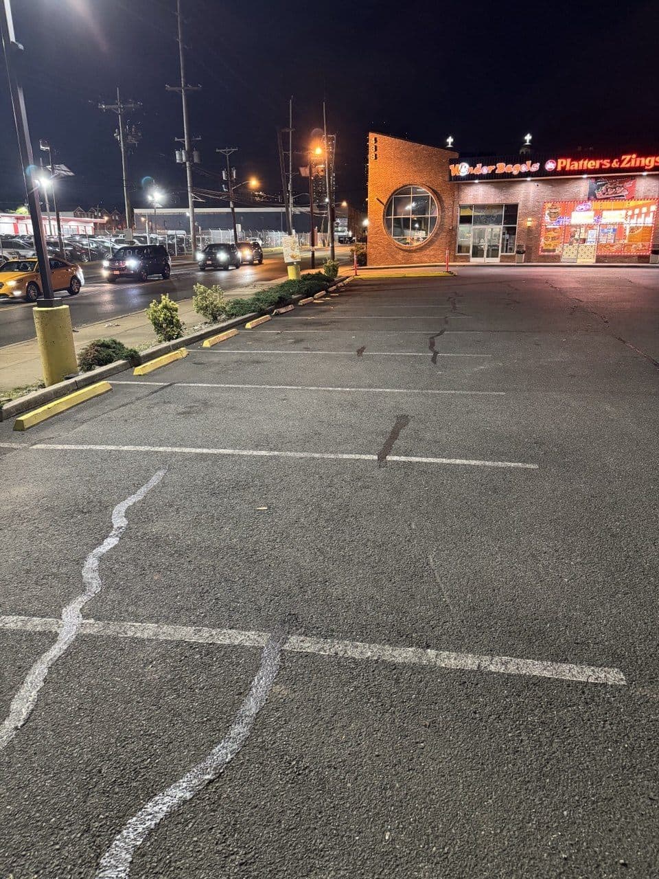 Faded, worn parking stall lines at Wonder Bagels before re-striping, Jersey City, NJ