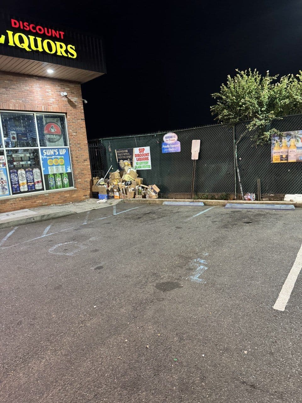 Worn parking lot with faded handicap markings before striping at Discount Liquors, Jersey City, NJ