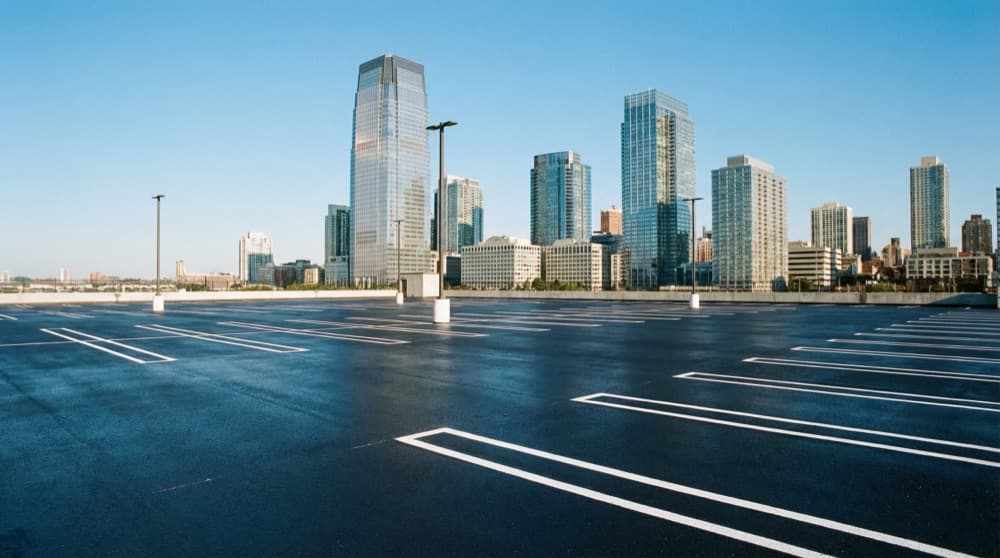 Professional sealcoating work on a Jersey City commercial property showing fresh pavement protection