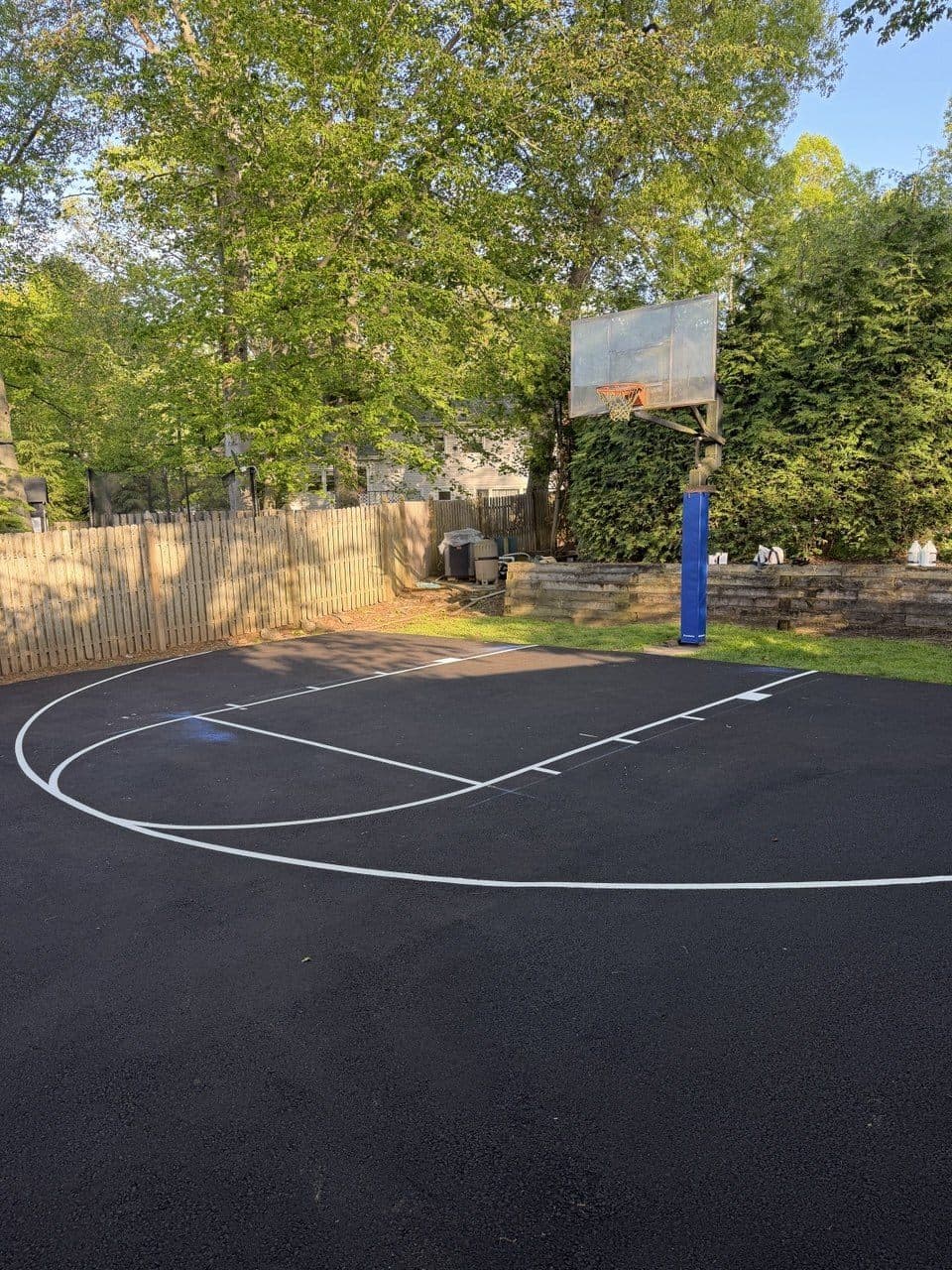 Freshly resurfaced backyard basketball court with crisp white lines in New Jersey