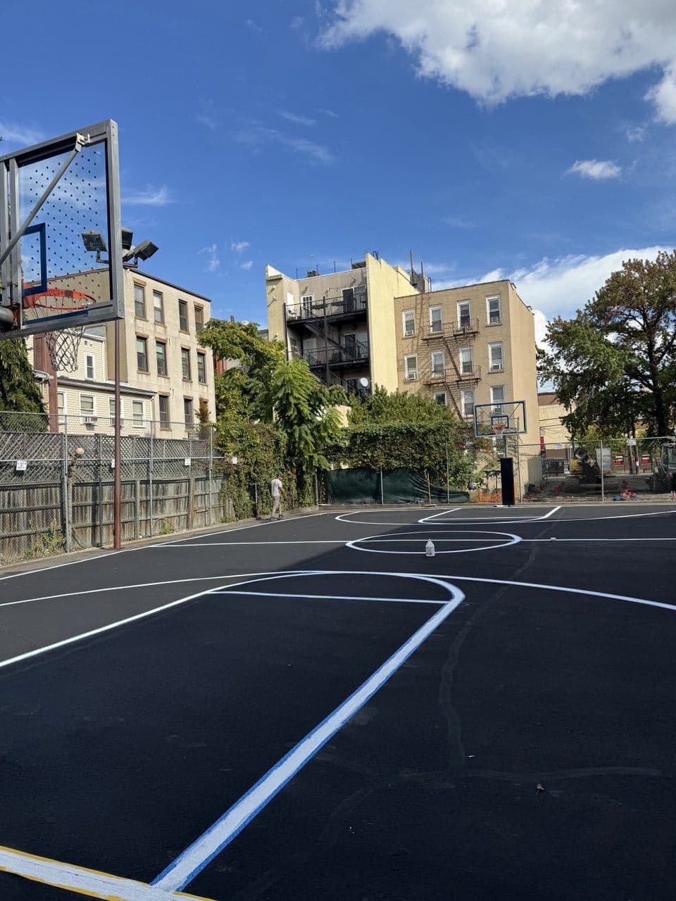 Crew striping fresh white and blue lines on the Hoboken Boys & Girls Club basketball court