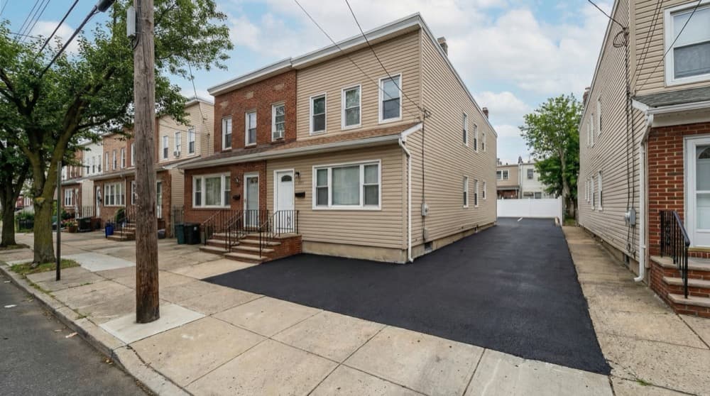 Professional sealcoating work on a Bayonne property showing fresh pavement protection